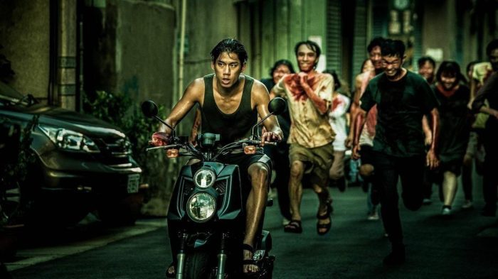 Fotograma de la película The Sadness (2021), donde un hombre en moto es perseguido por zombies