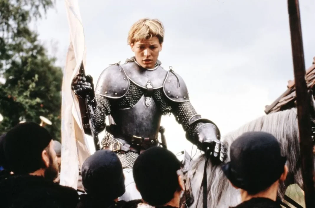 Fotograma de Juana de Arco de Luc Besson (The Messenger: The Story of Joan of Arc, 1999); en el que Juana de Arco sostiene una bandera blanca sobre un caballo blanco